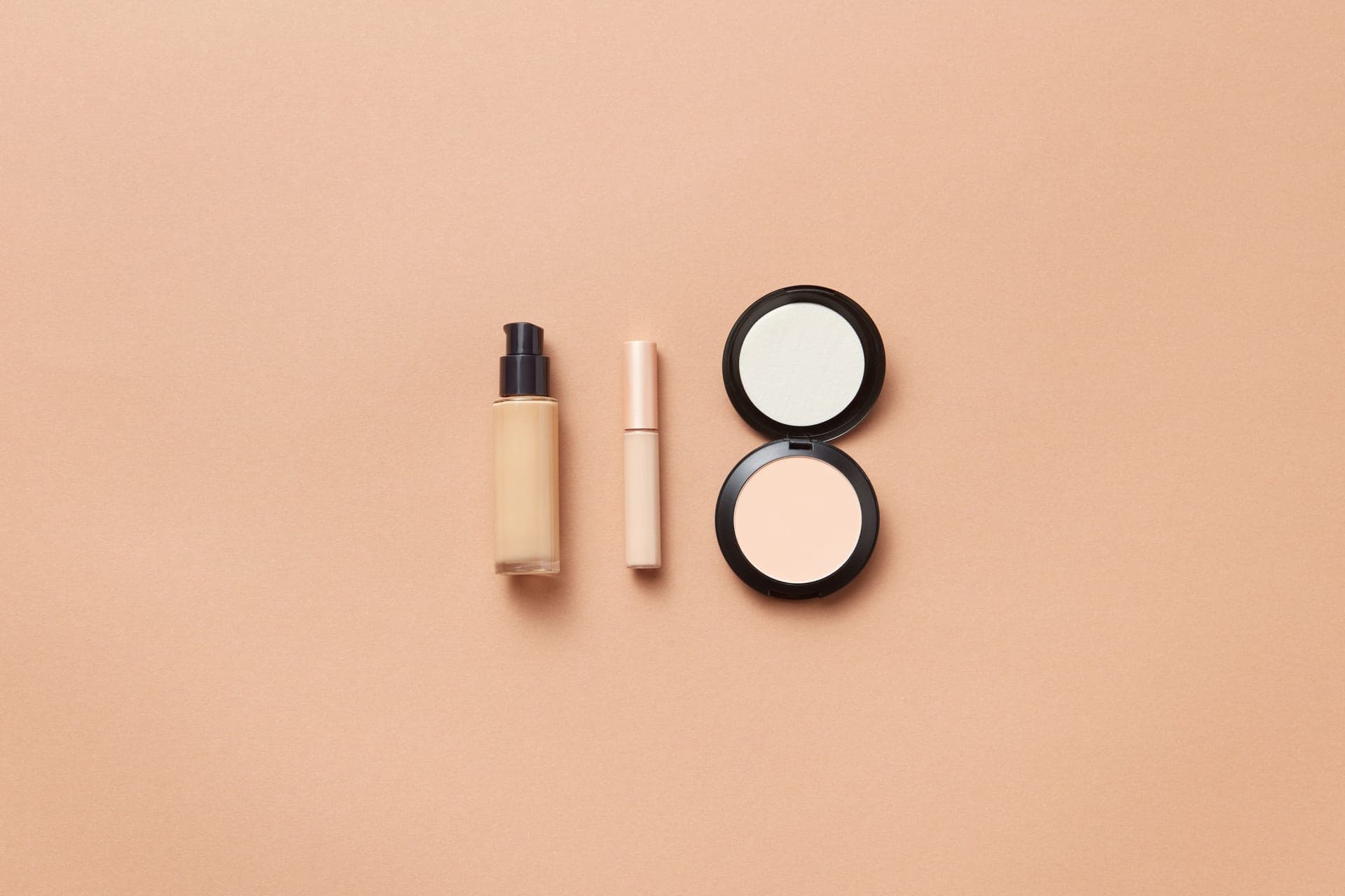 Two unbranded serum bottles side by side on a warm neutral background